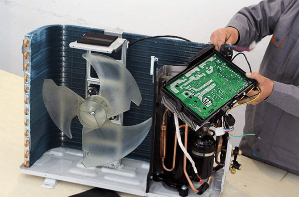 a man is checking the main board of outdoor unit
